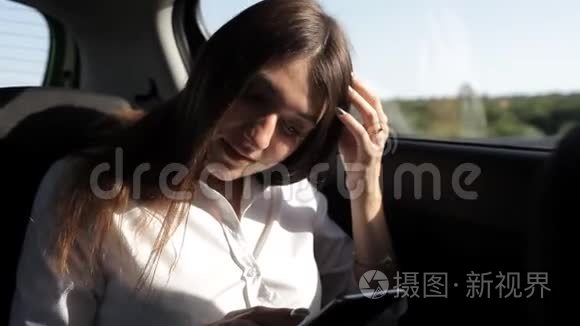 年轻的女商人坐出租车享受电话视频