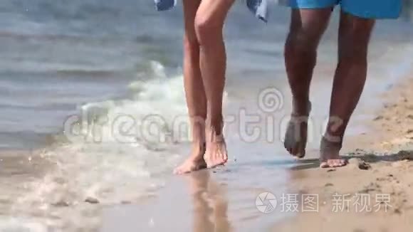 在海滩水边行走的特写双脚视频