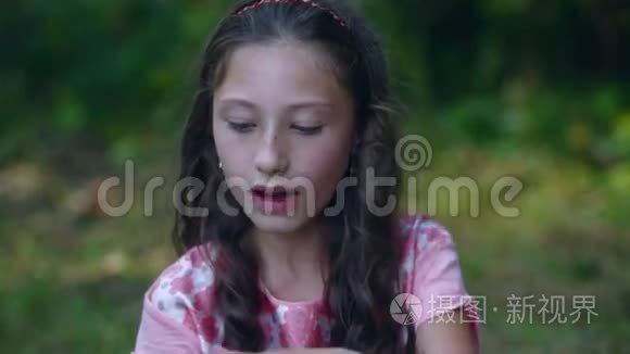漂亮的小女孩在花园里吃香蕉视频