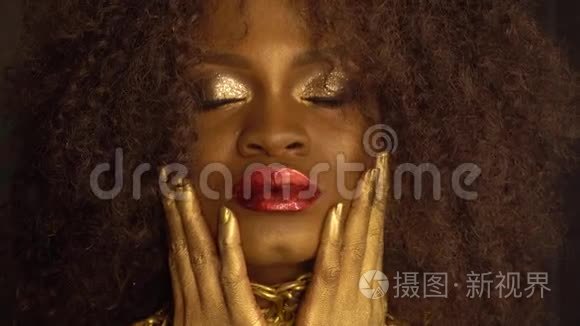 年轻的非裔美国女性模特的特写时尚肖像，金色光泽的妆容。 面子艺术。 黑人工作室