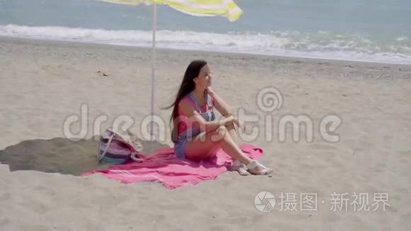 单身女人在海滩伞下放松视频