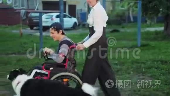 妈妈带着狗和儿子坐轮椅走路视频