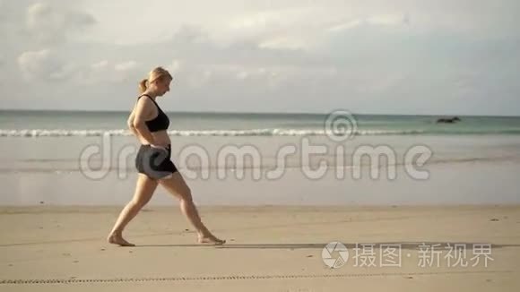 年轻的金发女人在海滩上做运动视频