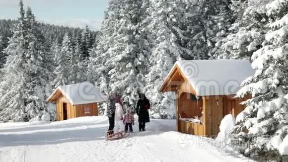 带雪橇的家庭参观小木屋视频