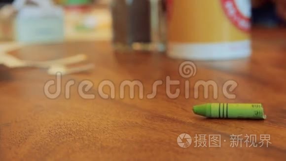 棕色木桌上的绿色彩色蜡笔卷视频