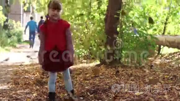 穿红色背心的小女孩扔树叶视频