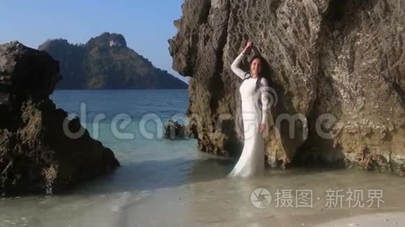 新娘站在透明的水中，靠在岩石上
