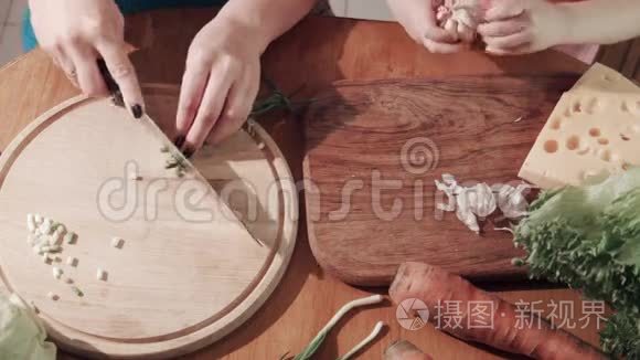 母女俩在木板上切洋葱和大蒜视频