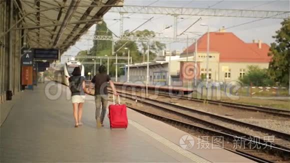 一对夫妇带着手提箱在火车站跑视频