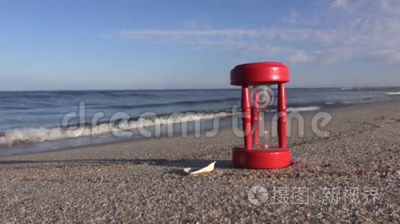 古老的红碎沙漏沙漏钟在沙滩上视频