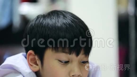 亚洲可爱男孩在家里地板上看书视频
