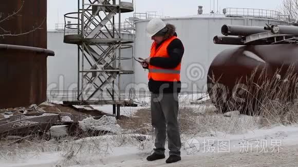 工程师在油罐附近使用平板电脑视频