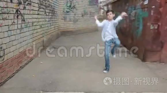 少年跳舞，在砖墙的背景上跳舞