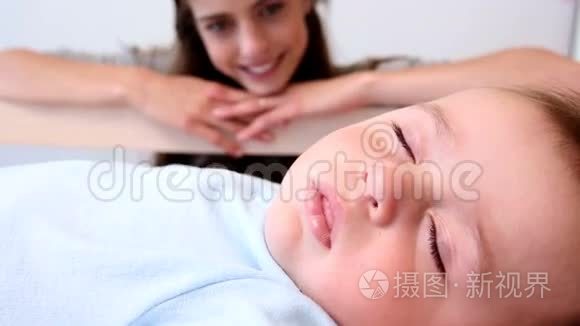 快乐的母亲照看婴儿床上的儿子视频