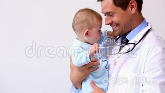 英俊的儿科医生抱着小男孩视频