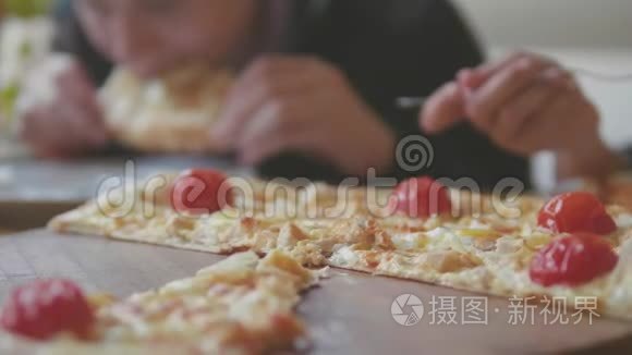 男孩和女孩在咖啡厅慢动作视频中吃披萨。 孩子们吃比萨饼，吃美味的比萨饼。 生活方式公司