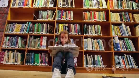 坐在图书馆地板上看书的漂亮学生