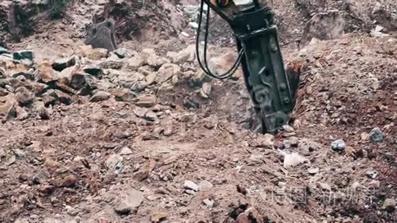 关闭一个重型建筑行业挖掘机在一个建筑工地的石头破碎