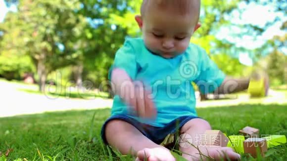 可爱的小男孩在草地上玩积木视频