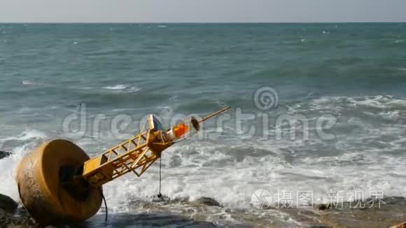 蔚蓝海岸的黄色大浮标。 波浪撞击浮标