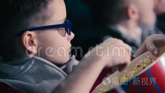 那个小男孩正在电影院吃爆米花视频
