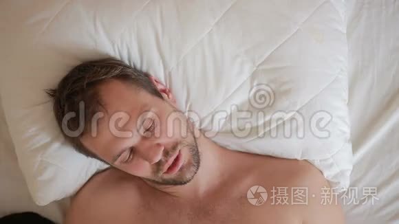 一个发烧的男人躺在家里的床上视频