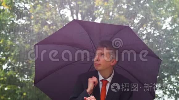 白人商人躲在雨中的伞下视频