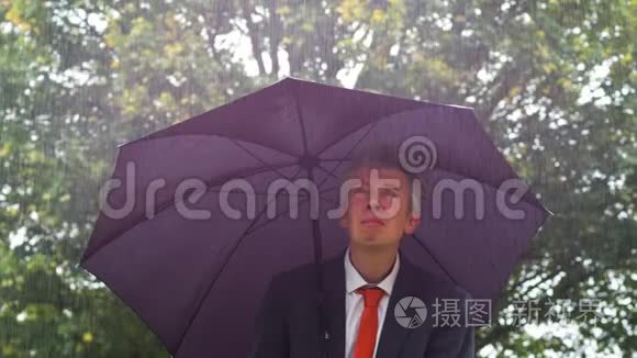 白人商人躲在雨中的伞下视频