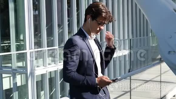 时尚的年轻商务男士带耳机视频