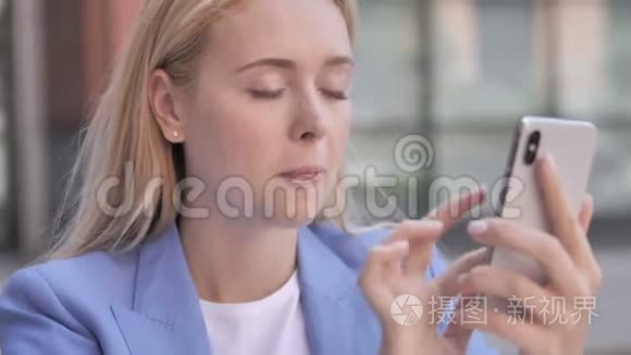 年轻的女商人使用智能手机视频