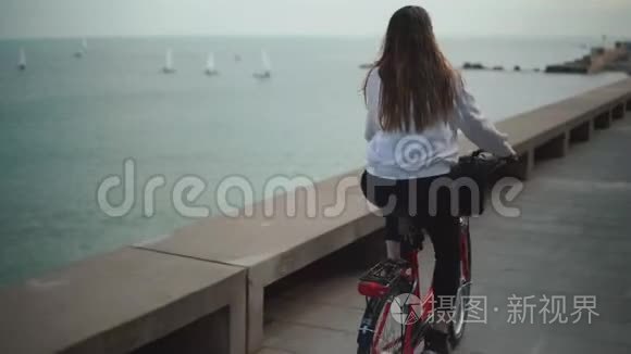 夏天骑自行车的女人在海滩上