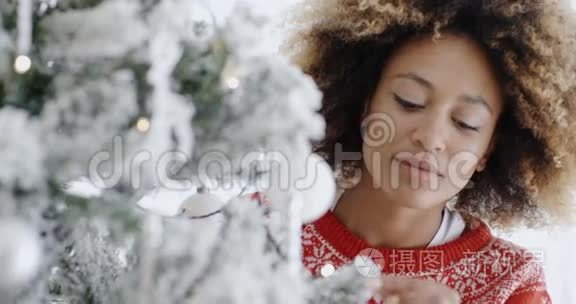 一个漂亮的年轻女人在装饰圣诞树