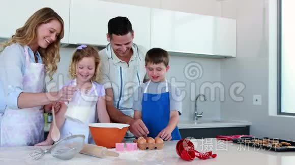 快乐的年轻家庭一起做蛋糕