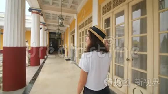 旅游妇女在夏季旅行时漫步在柱廊古建筑上