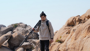 风光摄影师扛着相机登山50秒视频