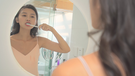 女性在卫生间对着镜子刷牙视频