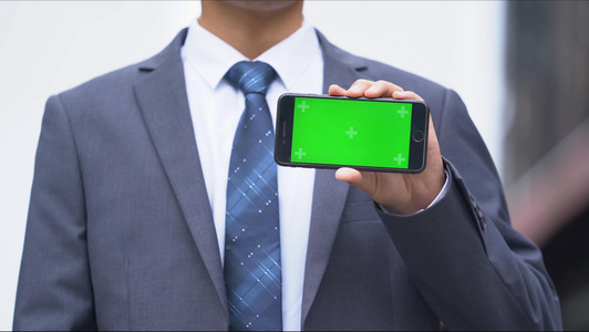4k穿西装的办公男生展示绿幕手机[西装裤]视频