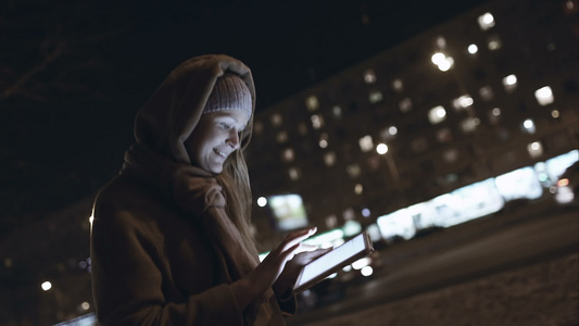 女人在晚上城市的路上打字时身上有触摸板视频