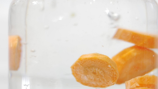 新鲜胡萝卜块的慢动作镜头溅水和玻璃中的气泡素食主义者视频