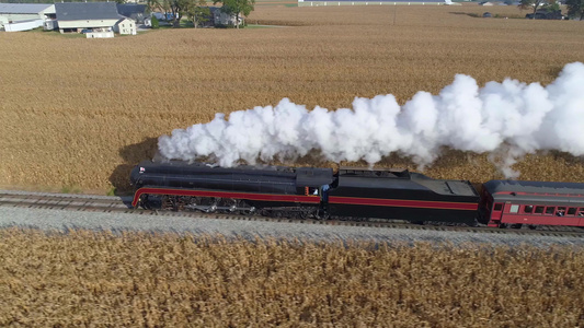 蒸汽机的恢复后蒸汽机空中侧面在拖着客车驶往农田时发视频