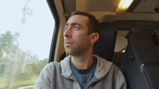 年轻人在火车上旅行看着窗外的窗户视频