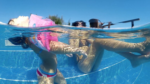 家庭在温泉池游泳和提神带充气臂章漂浮在水面上的小女孩30秒视频