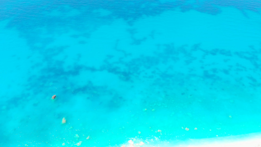 具有岩石美丽自然背景的透明绿绿海海水的空中观测图视频