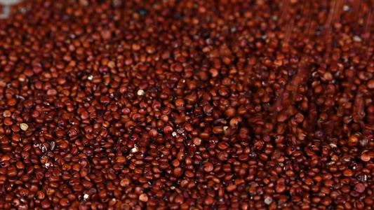 在木制桌上掉落的红色quinoa种子视频