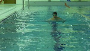 戴帽子和护目镜的男子在游泳池里游泳15秒视频