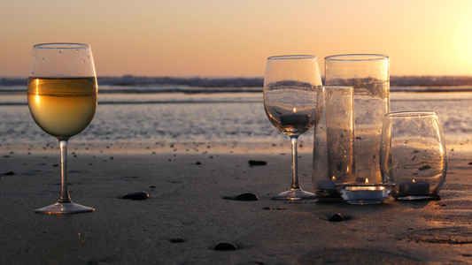 玻璃烛火海浪浪漫海滩约会夏日大海沙滩上的烛光视频