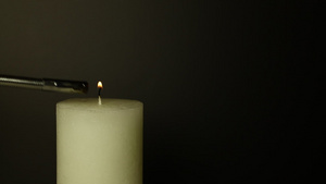 白蜡烛紧紧闭火焰在黑漆漆的面罩上颤抖26秒视频