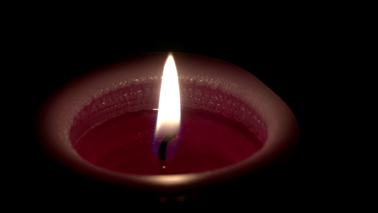 在黑暗背景上紧紧地关在燃烧的蜡烛上视频