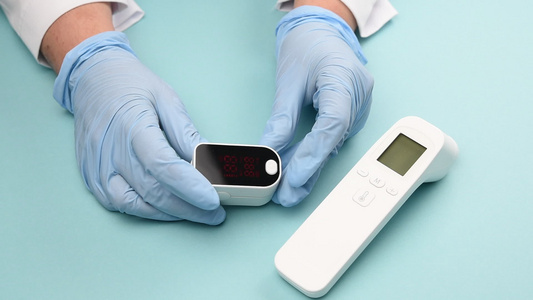 白色电子非接触性温度计和血氧表蓝底的血液氧测量仪视频