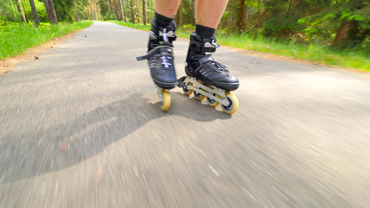 男人在森林沥青路上滑过滚轮滑雪近距离观察内衬靴的快速视频